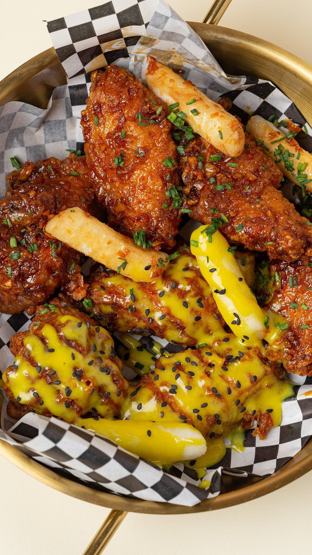 Tray of fried chicken wings with battered fries and cheese sauce