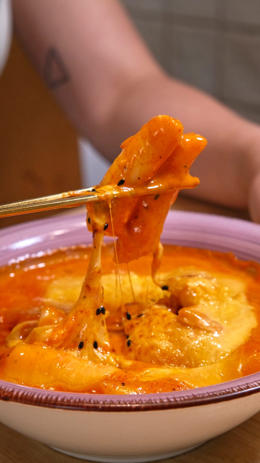 Tteokbokki with melted cheese and black sesame